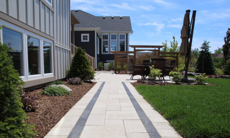 Finished patio stone walkway beside luxurious home